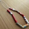 A completed bracelet made from vibrant, handmade paper beads