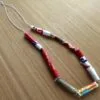 A completed bracelet made from vibrant, handmade paper beads